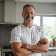 Porträt eines Mannes mittleren Alters, der stolz seine verbesserte Fitness demonstriert.